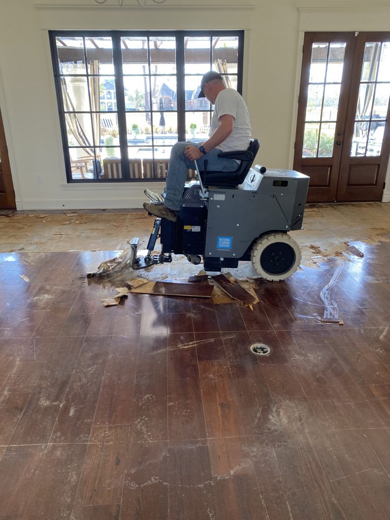 Wood flooring being removed with floor scraper